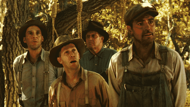John Turturro, George Clooney, and Tim Blake Nelson gawk at something off-screen, standing under a tree with three nooses hung on it.