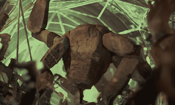 Still of an alien creature that looks like a spider made of rocks.