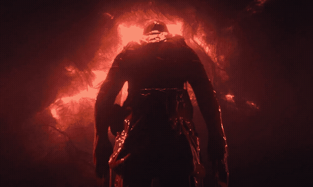 Moody shot of a figure from the back in front of a mysterious red background.