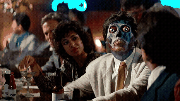 Some people are sitting at a bar. One of them is a weird blue skull alien with a normal guy's hair.
