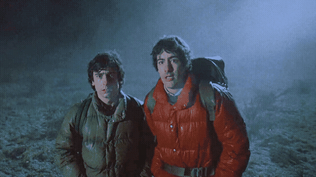 Two guys in puffer jackets look scared in a foggy field.